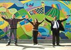 Two men and woman with hands lifted 